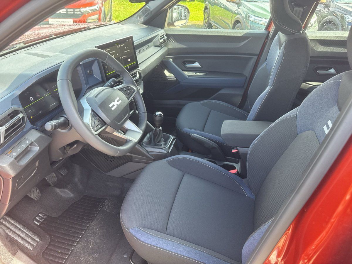 Dacia Innenraum mit Ledersitzen, Touchscreen und Schaltgetriebe – Fahrerseite
