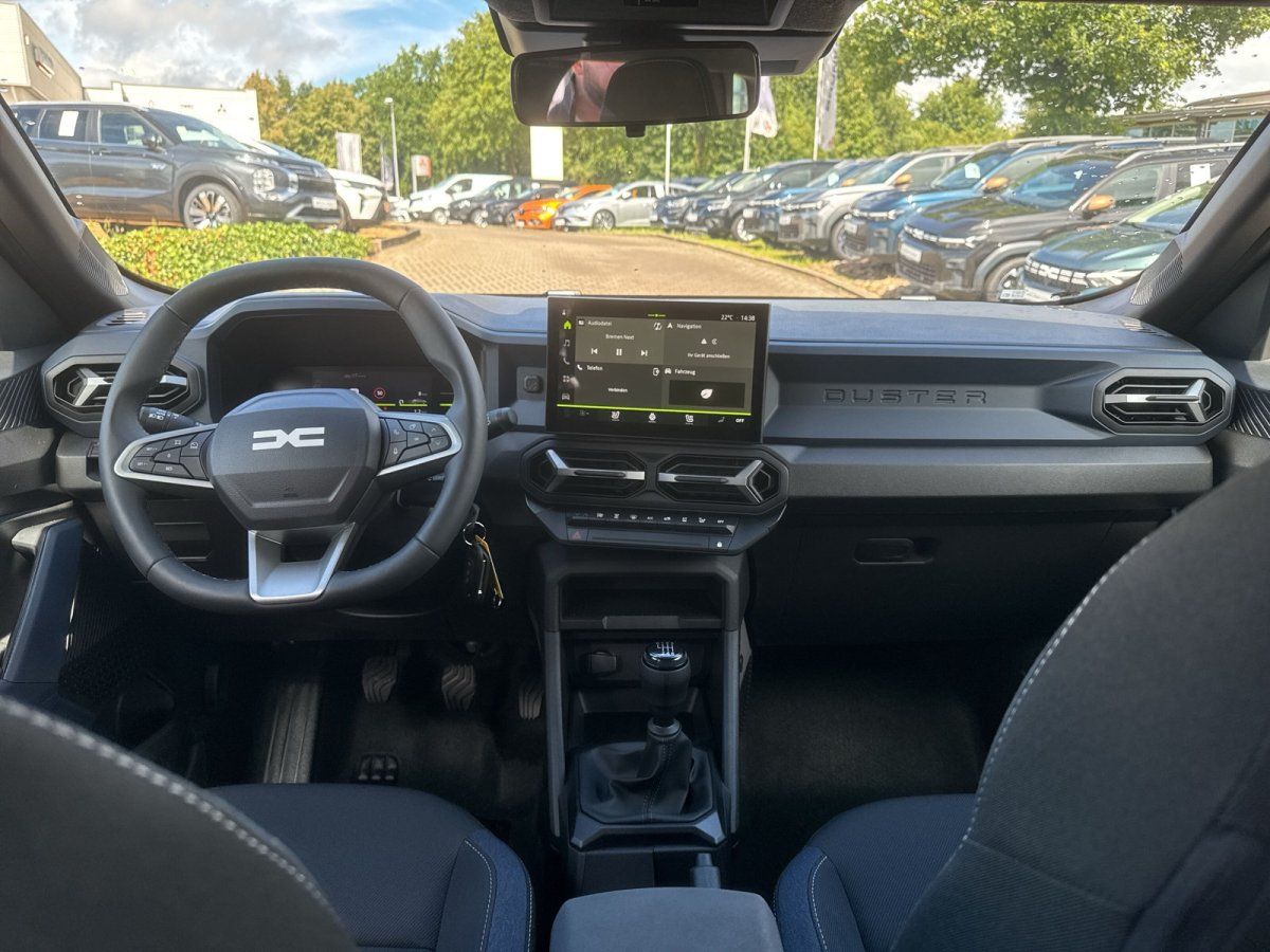 Dacia Duster Innenraum mit Touchscreen-Navigation, Lederlenkrad und Schaltgetriebe im Autohaus