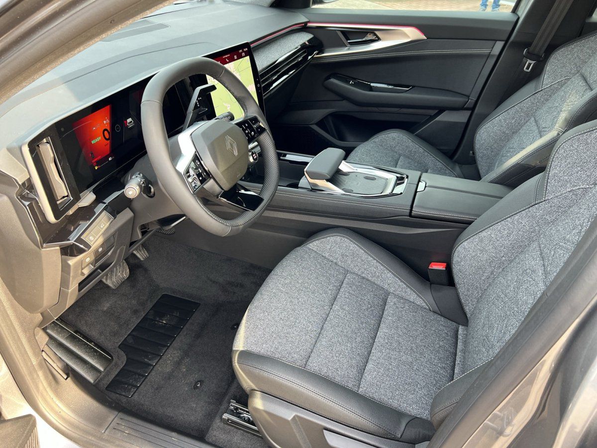 Fahrzeuginnenraum mit schwarzem Cockpit, Lenkrad und modernem Display