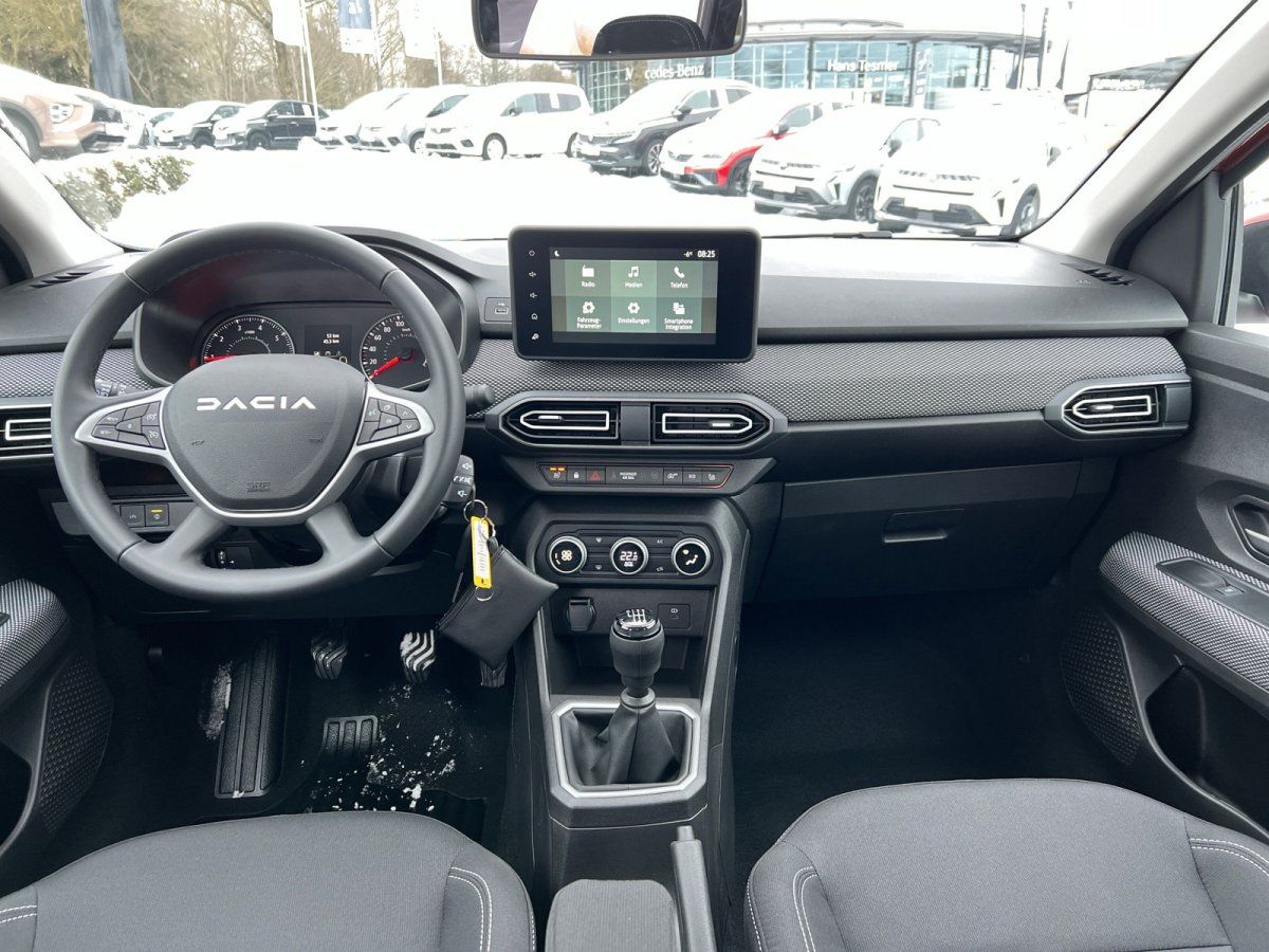 Dacia Innenraum mit Lenkrad, Touchscreen und Schaltgetriebe im Autohaus