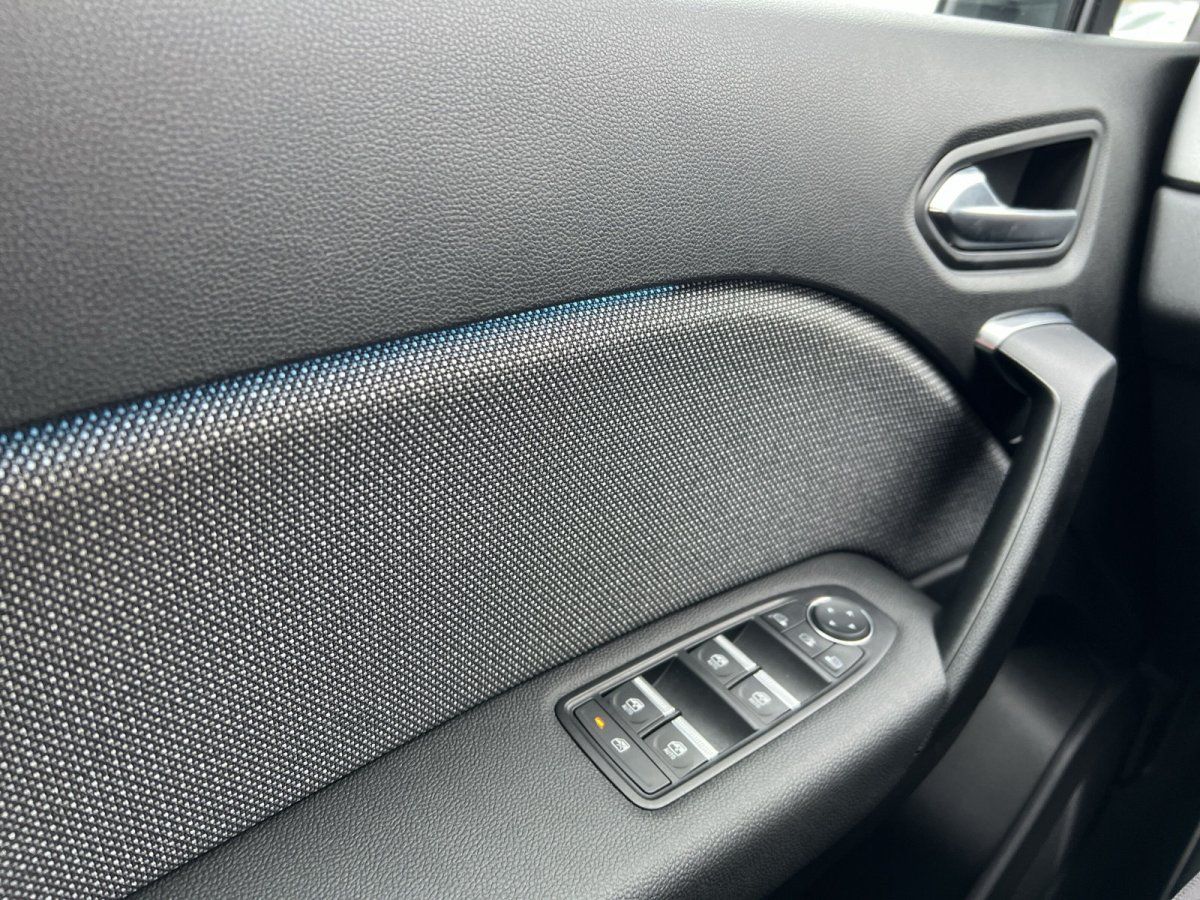 Fahrzeugtür von innen in modernem Autohaus mit mehreren Ausstellungsfahrzeugen im Hintergrund