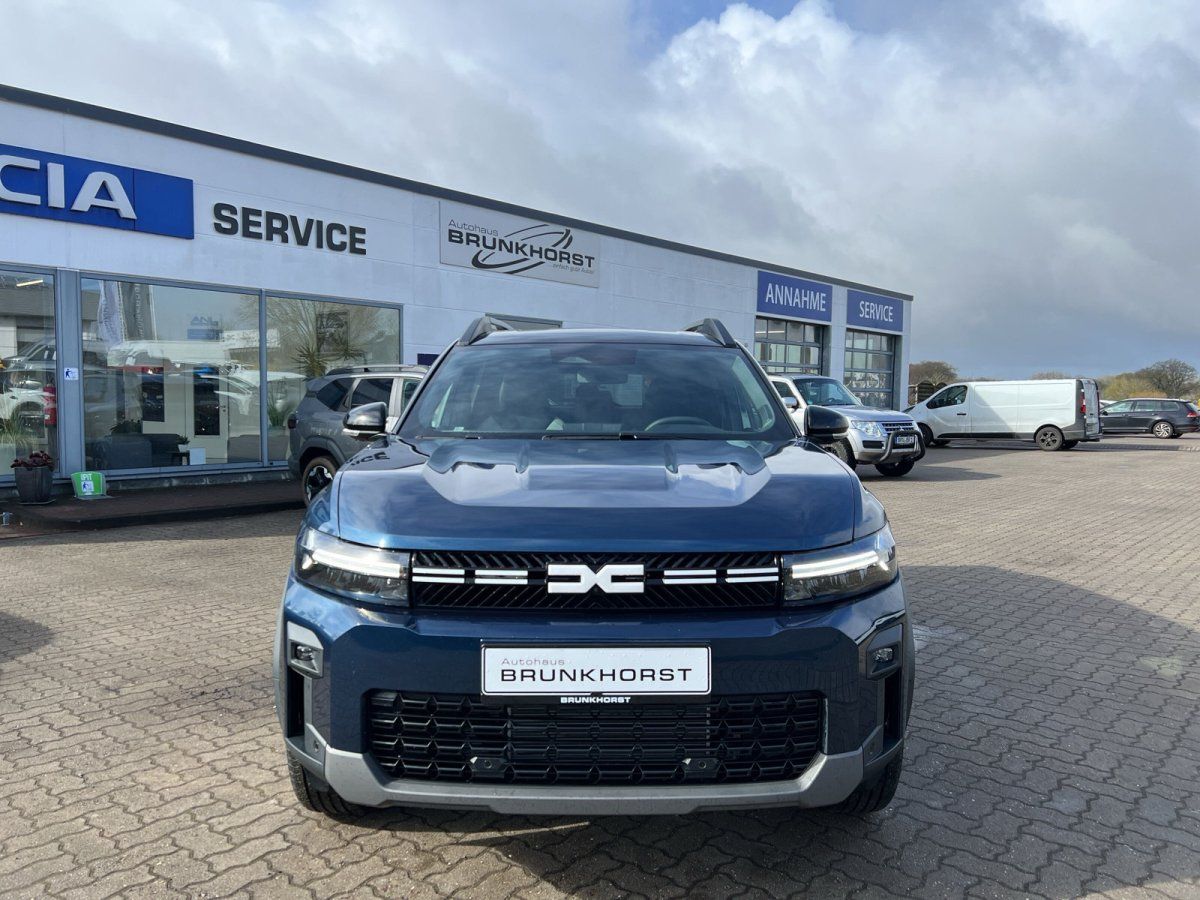 Dacia SUV Frontansicht in blau-grauer Lackierung im hellen Autohaus-Showroom