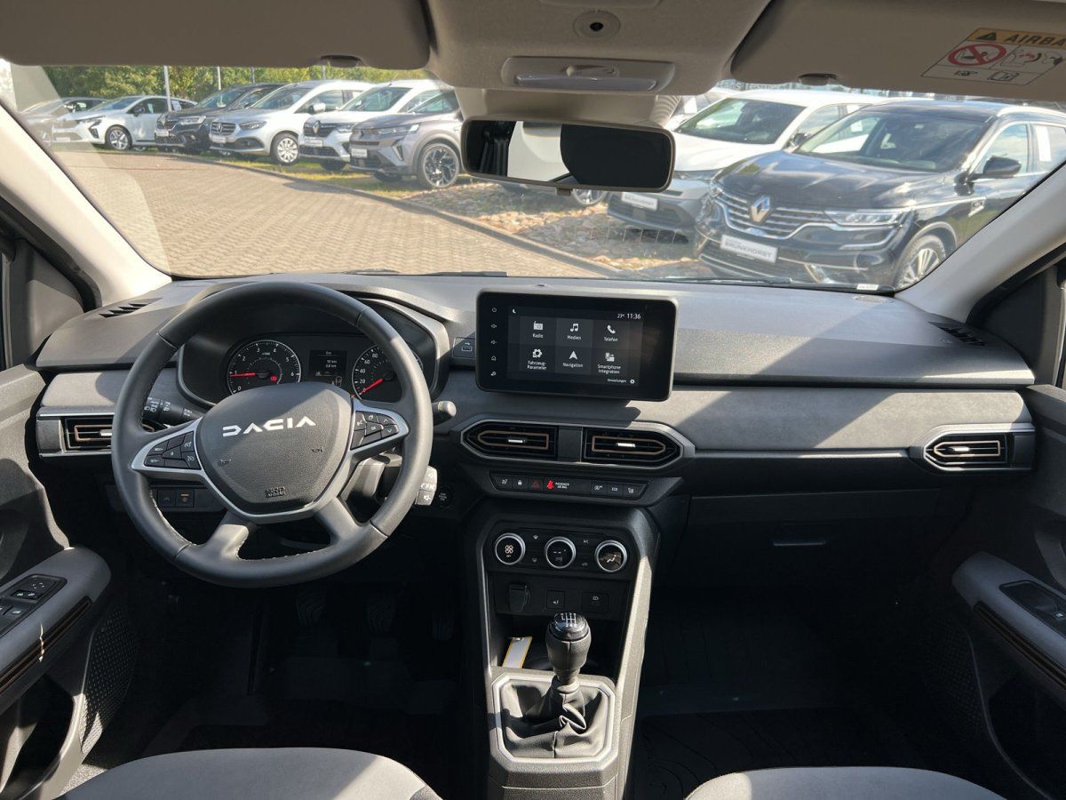 Dacia Innenraum mit Lenkrad, Infotainment-Display und Schaltgetriebe – modernes Cockpit