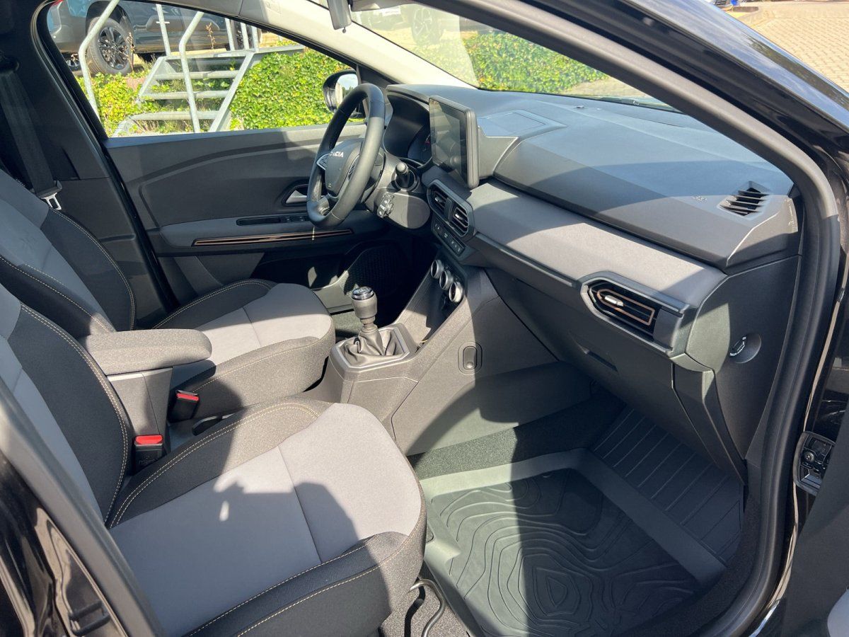 Dacia Sandero Innenraum mit Schaltgetriebe, Touchscreen und grauen Stoffsitzen in Autohaus