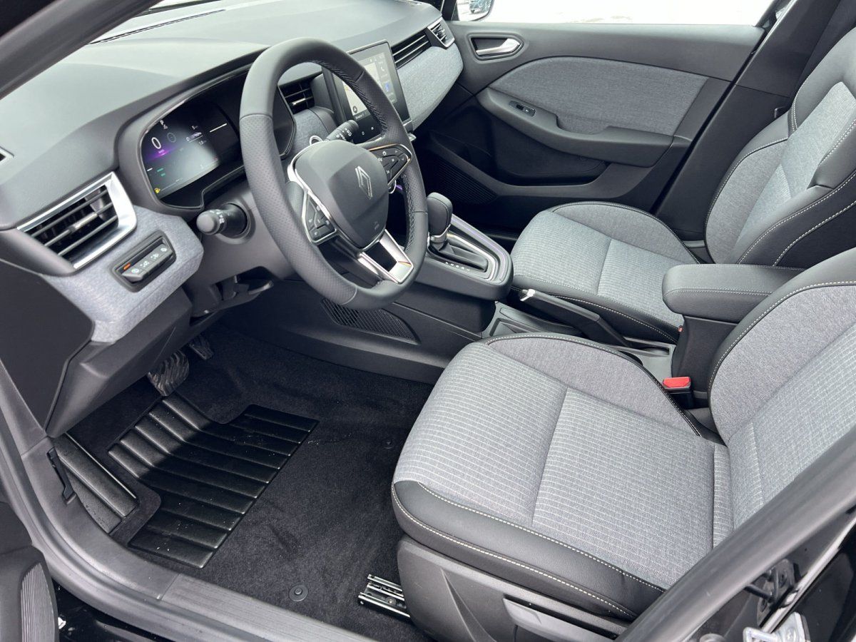 Renault Innenraum mit grauem Stoffsitz, Lenkrad und digitalem Kombiinstrument im Autohaus