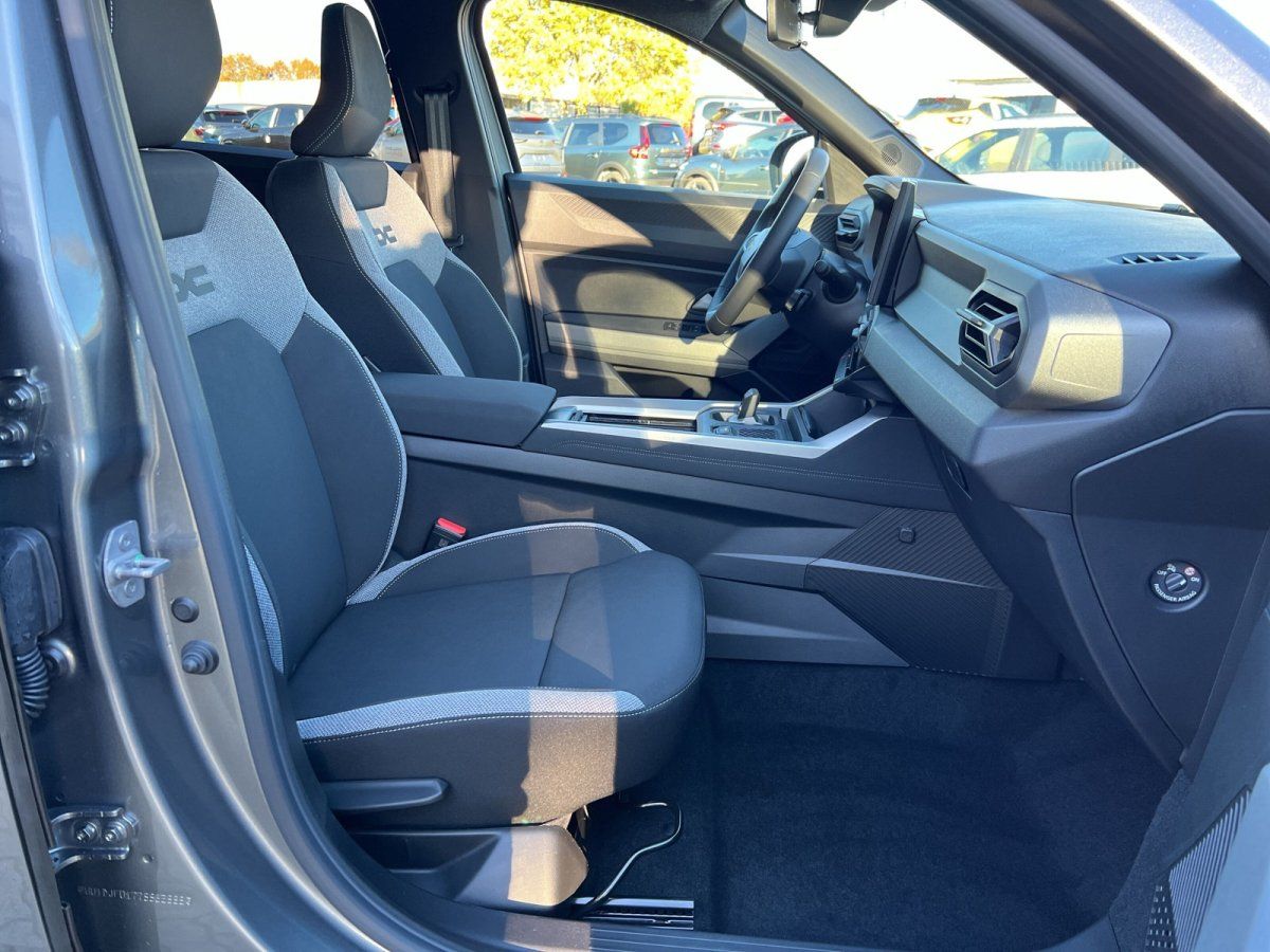 Dacia Innenraum Vordersitze mit sportlichem Sitzbezug und moderner Mittelkonsole im Autohaus