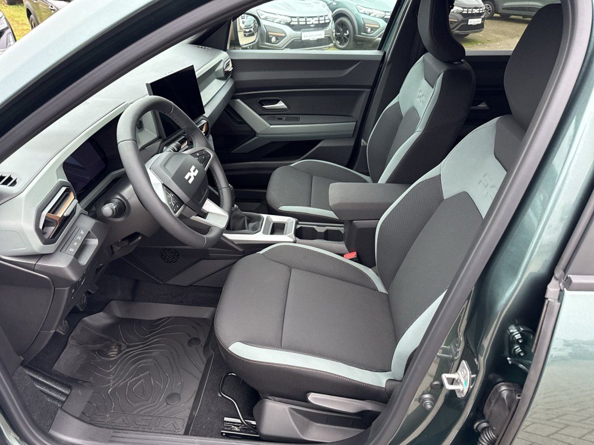 Dacia Innenraum mit schwarzen Sportsitzen, Lenkrad und Infotainment-Display im Autohaus