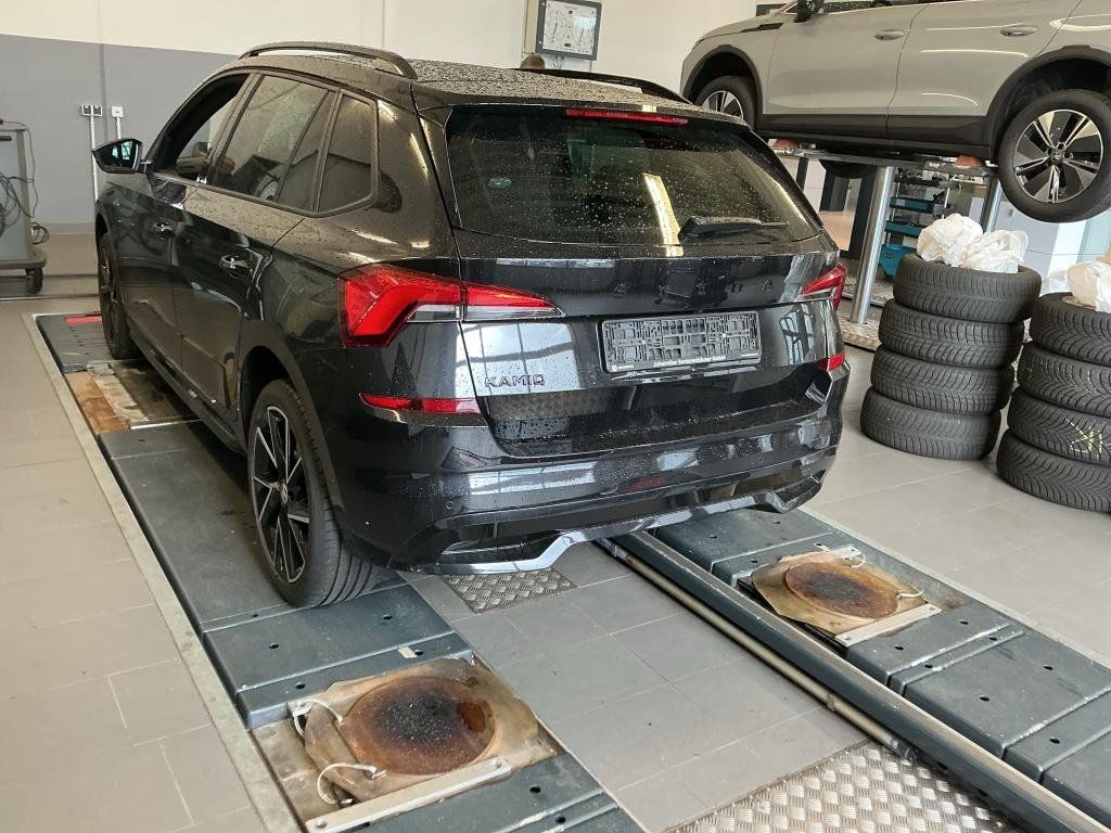 Schwarzer Skoda Kamiq von hinten in der Werkstatt auf der Hebebuehne