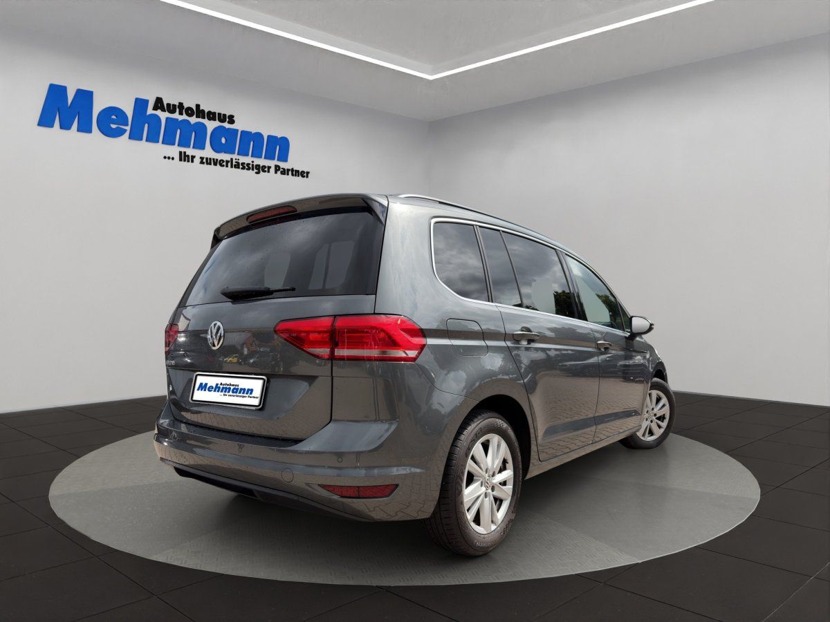 VW Touran grau Heck-Seitenansicht im Autohaus Showroom