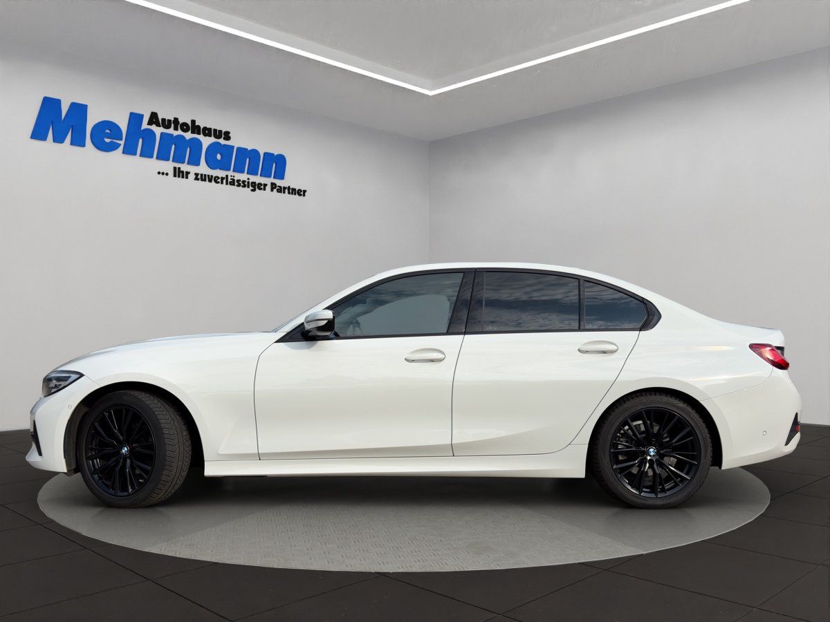 BMW 3er Limousine weiß Seitenansicht mit schwarzen Felgen im Showroom