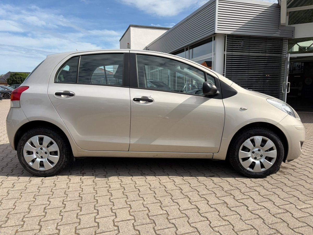 Toyota Yaris beige Seitenansicht geparkt vor Autohaus