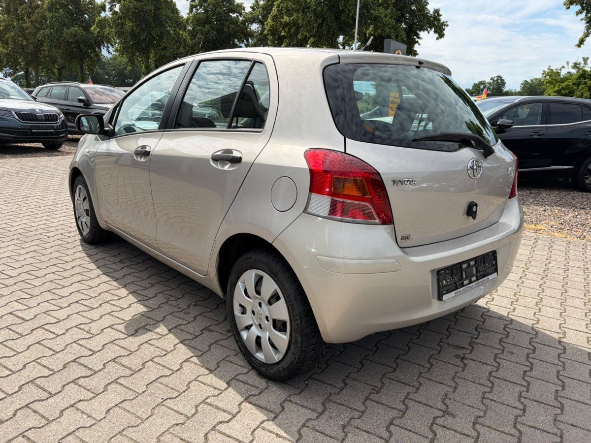 Toyota Yaris beige Heckansicht schraeg im Freien