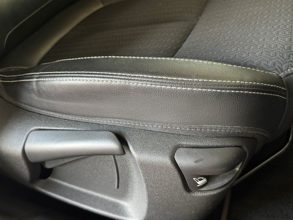 Detailansicht Sitzverstellung und Ledernaht im Fahrzeuginnenraum