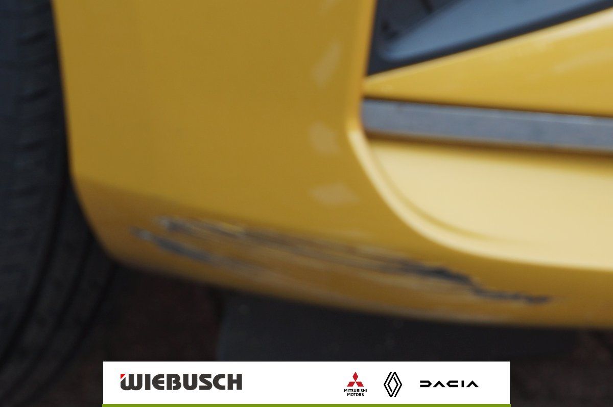 Detailansicht Stoßstange Mitsubishi in gelb mit kleiner Lackschramme