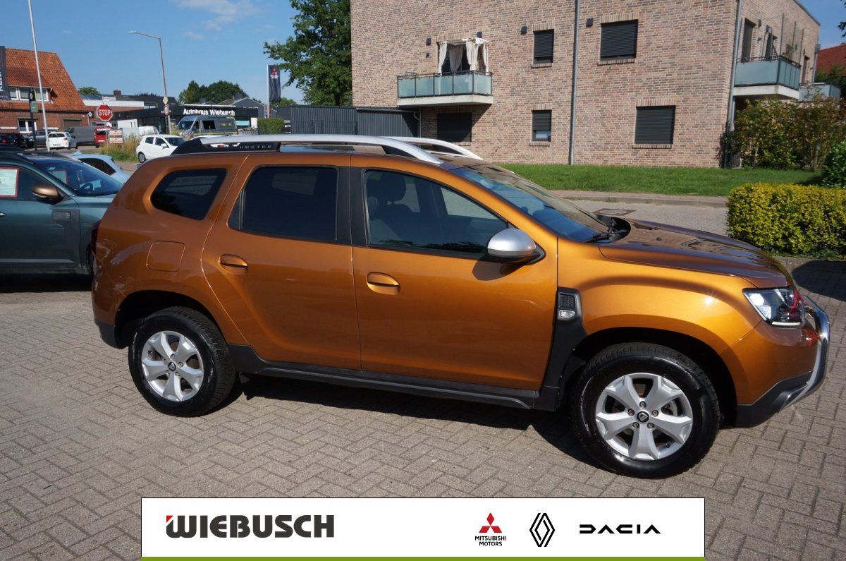 Dacia Duster orange Seitenansicht auf Parkplatz beim Autohaus Wiebusch