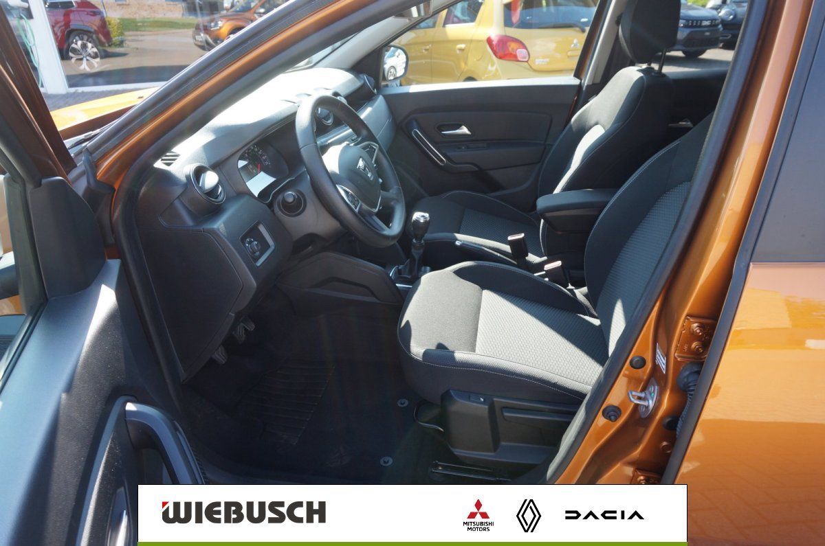 Dacia Innenraum mit Cockpit, Lenkrad und Vordersitzen in Schwarz-Grau