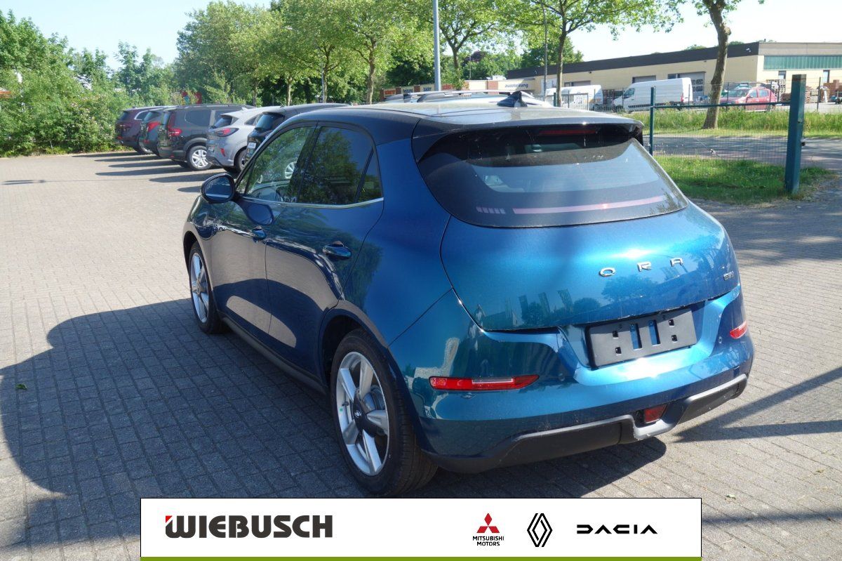 Ora in Blau metallic, Heckansicht mit Panoramadach auf Parkplatz