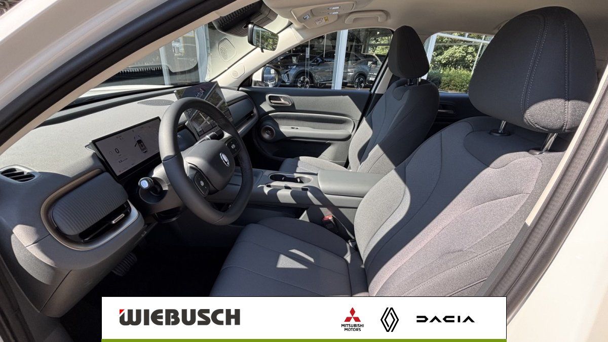 Innenraum eines Fahrzeugs mit Sitzen, Lenkrad und Cockpit-Display