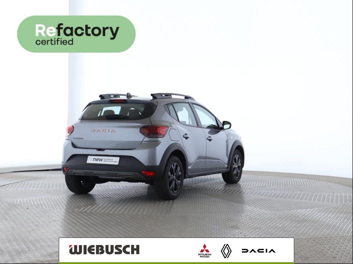 Dacia Sandero Stepway grau, Heckansicht mit Rückleuchten und Logo