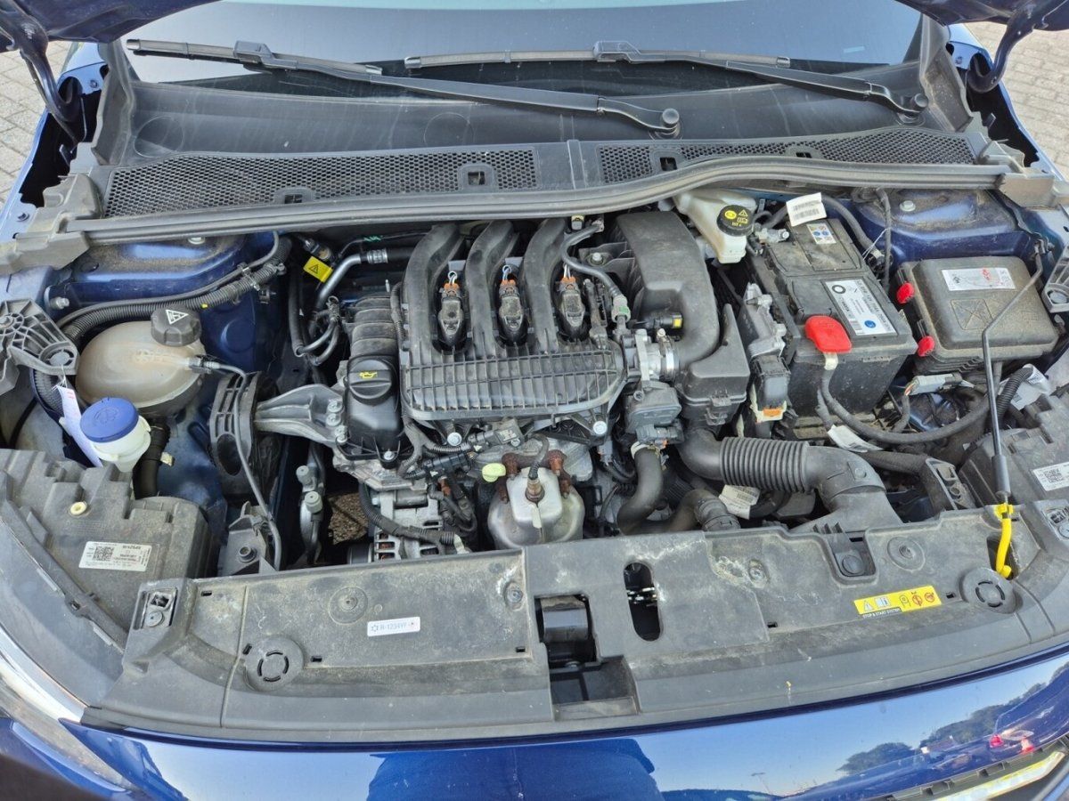 Motorraum eines blauen Fahrzeugs mit geoeffneter Motorhaube und Technikansicht