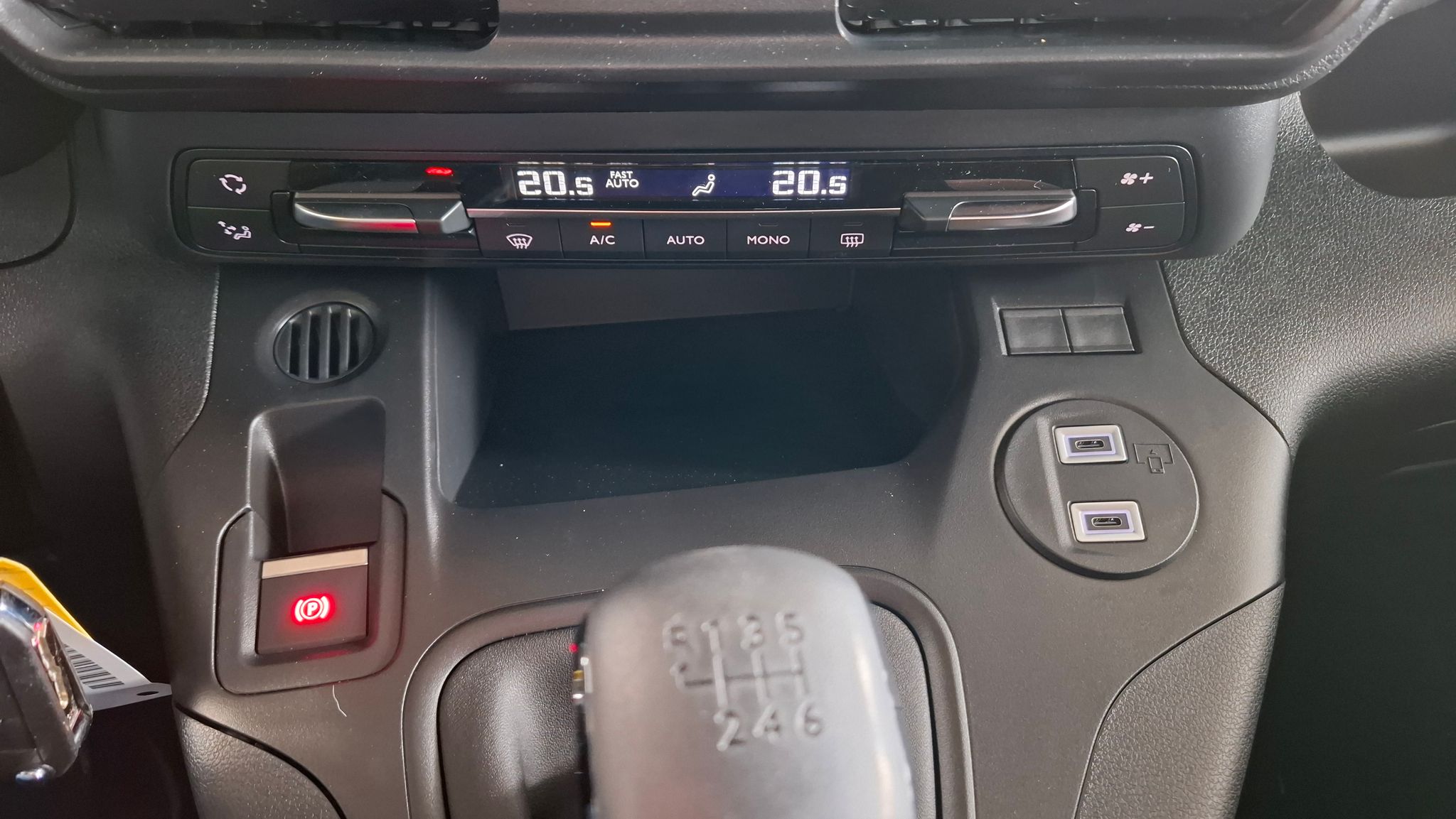 Citroën Autohaus Innenraum mit Schaltknauf und 6-Gang-Getriebe, elektronischer Parkbremse und USB-Anschlüssen im Armaturenbrett, Showroom mit Glasfassade im Hintergrund