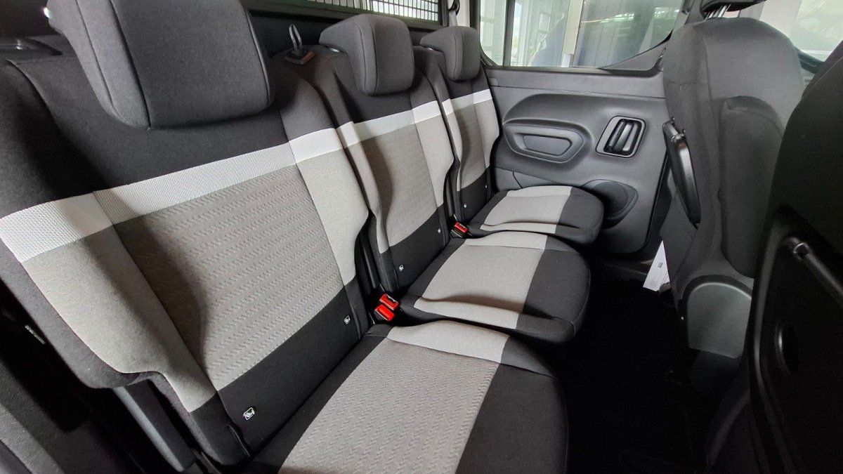 Fahrzeug-Rücksitzbank mit schwarzem und grauem Stoffbezug sowie Sicherheitsgurten im dunklen Innenraum