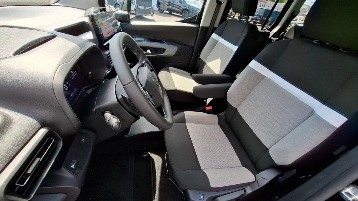 Fahrzeug-Innenraum mit zwei schwarzen Sportsitzen und beigen Akzenten in modernem Showroom