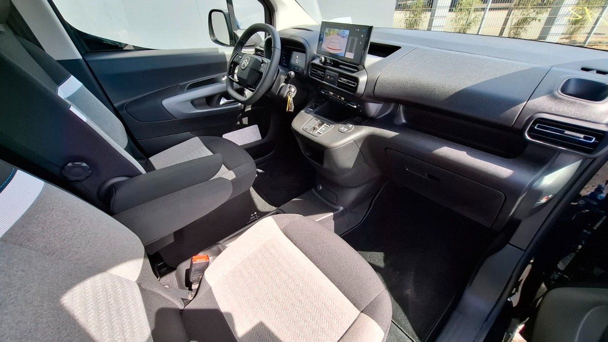 Modernes Fahrzeug-Cockpit mit Lenkrad, digitalem Display und blauer Ambientebeleuchtung