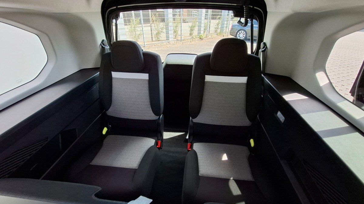 Modernes Fahrzeug-Innenraum mit geöffneten Schiebetüren, schwarze Sitze und LED-Ambientebeleuchtung