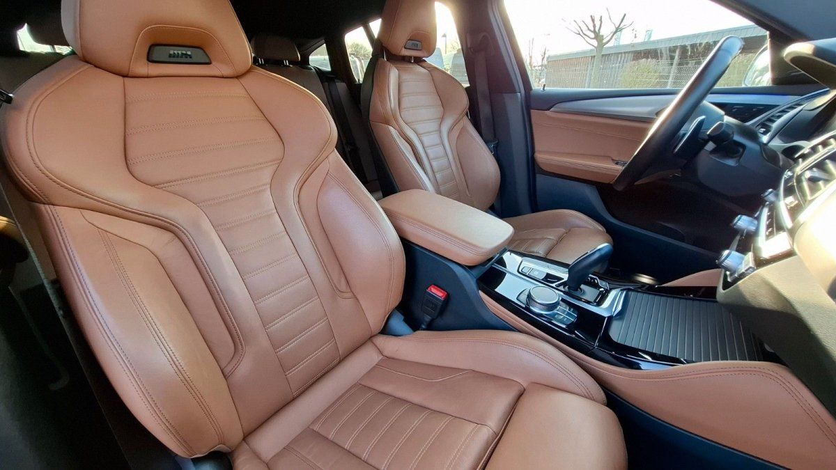 Luxuriöser Fahrzeuginnenraum mit cognacfarbenen Ledersitzen und modernem Mitteltunnel
