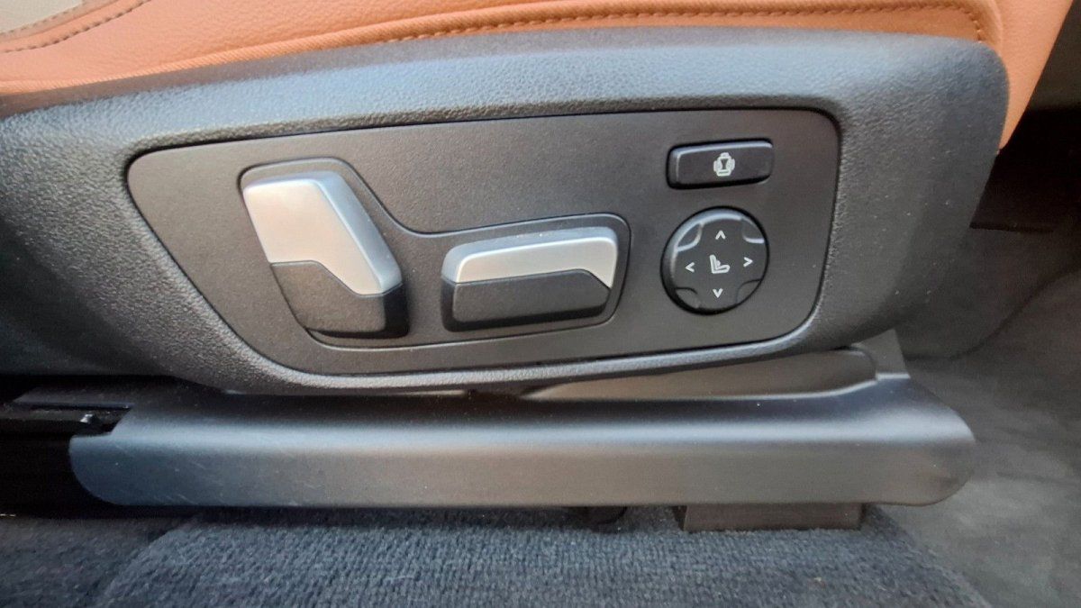 Elektrische Sitzverstellung mit Steuertasten im Fahrzeuginnenraum, brauner Lederakzent