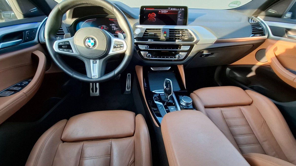 BMW X3 Innenraum mit Ledersitzen in Cognac, M-Sportlenkrad und iDrive-Touchscreen