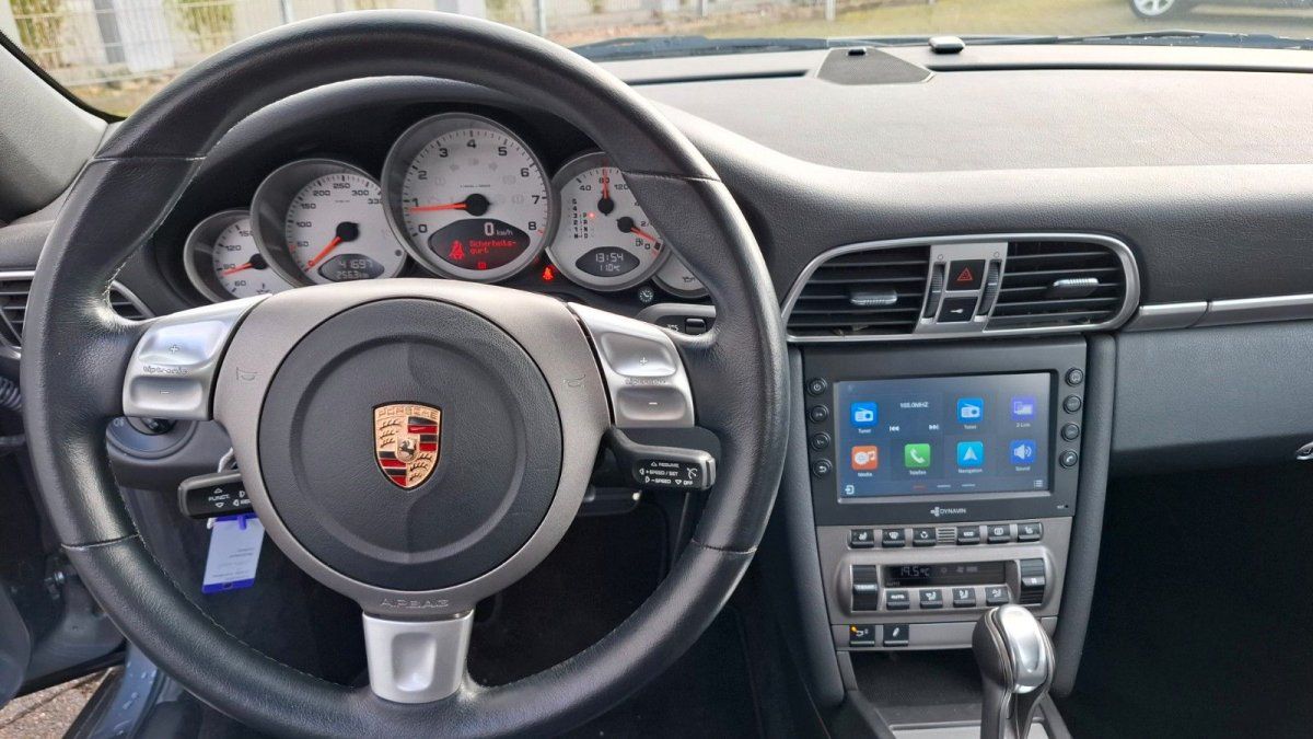 Porsche 911 Innenraum mit Lederlenkrad, Tacho und Apple CarPlay Touchscreen