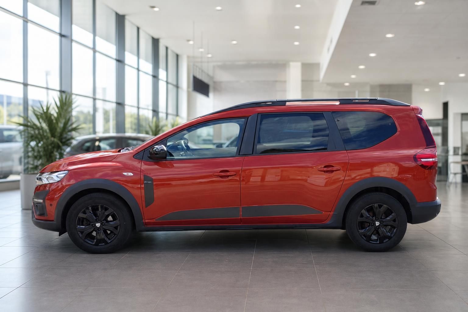 Roter Dacia Van/SUV Seitenansicht im Autohaus - modernes Design mit schwarzen Felgen