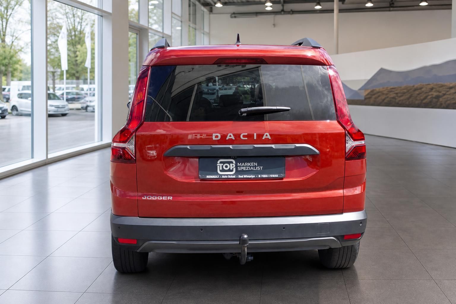 Dacia Jogger Heckansicht rot mit Kennzeichen und Händlerlogo im Autohaus