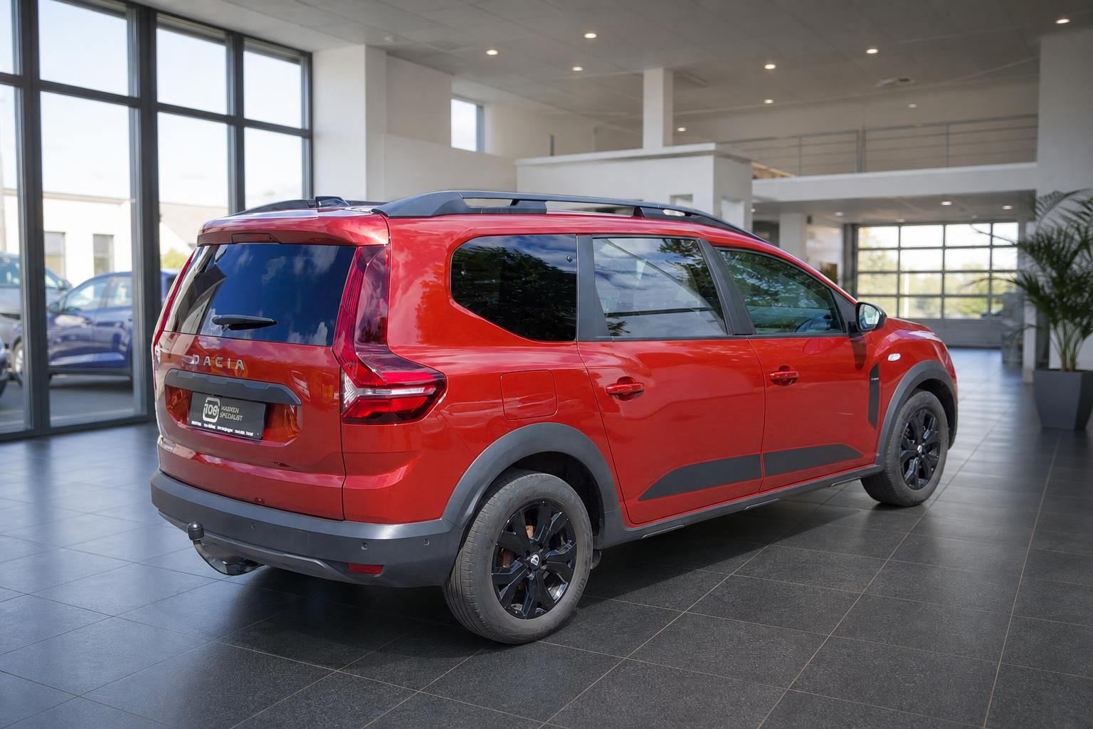 Roter Dacia Jogger schräge Heckansicht im Autohaus mit schwarzen Felgen und Dachreling