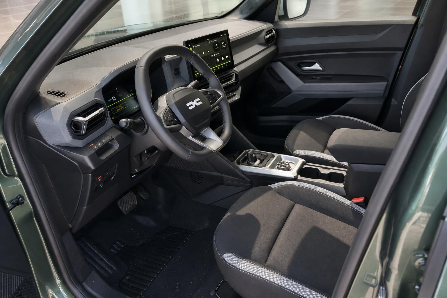 Dacia SUV Innenraum mit schwarzem Armaturenbrett, Touchscreen-Display und modernen Sportsitzen