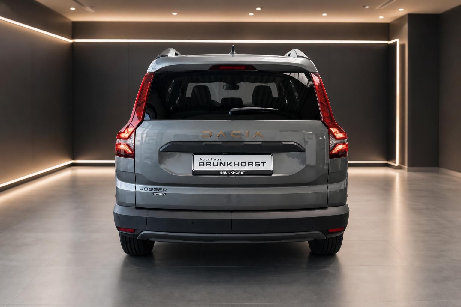 Dacia Jogger Hybrid Heckansicht grau metallic mit LED-Rückleuchten im Autohaus Showroom