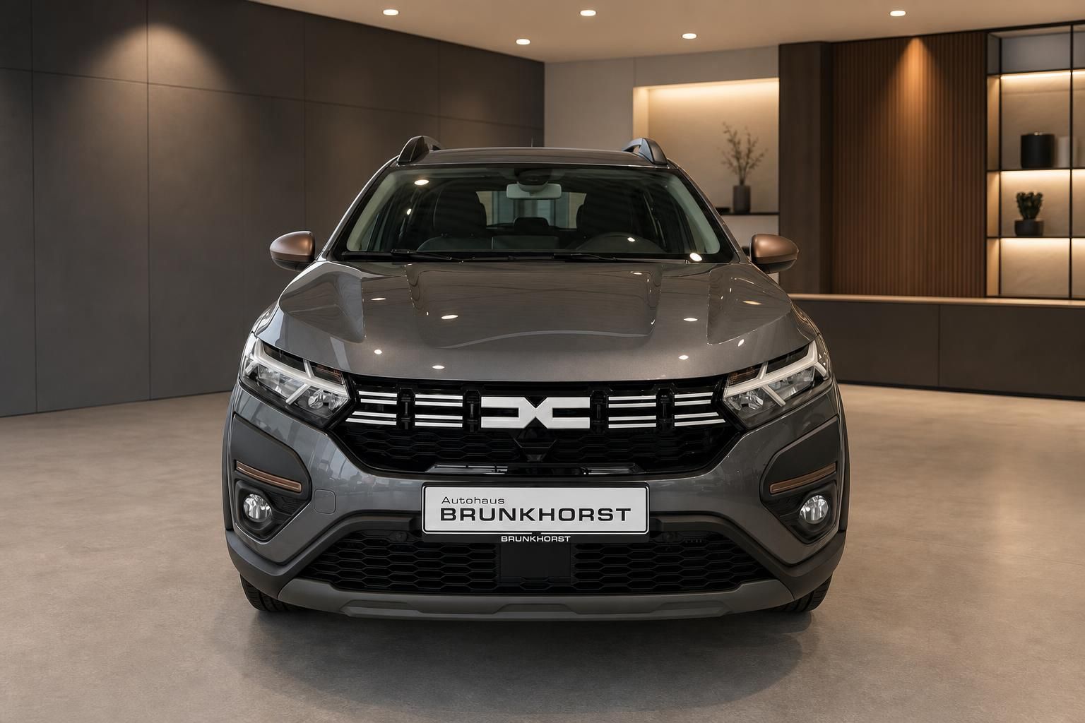Dacia SUV Frontansicht grau metallic mit LED-Scheinwerfern im eleganten Autohaus Showroom