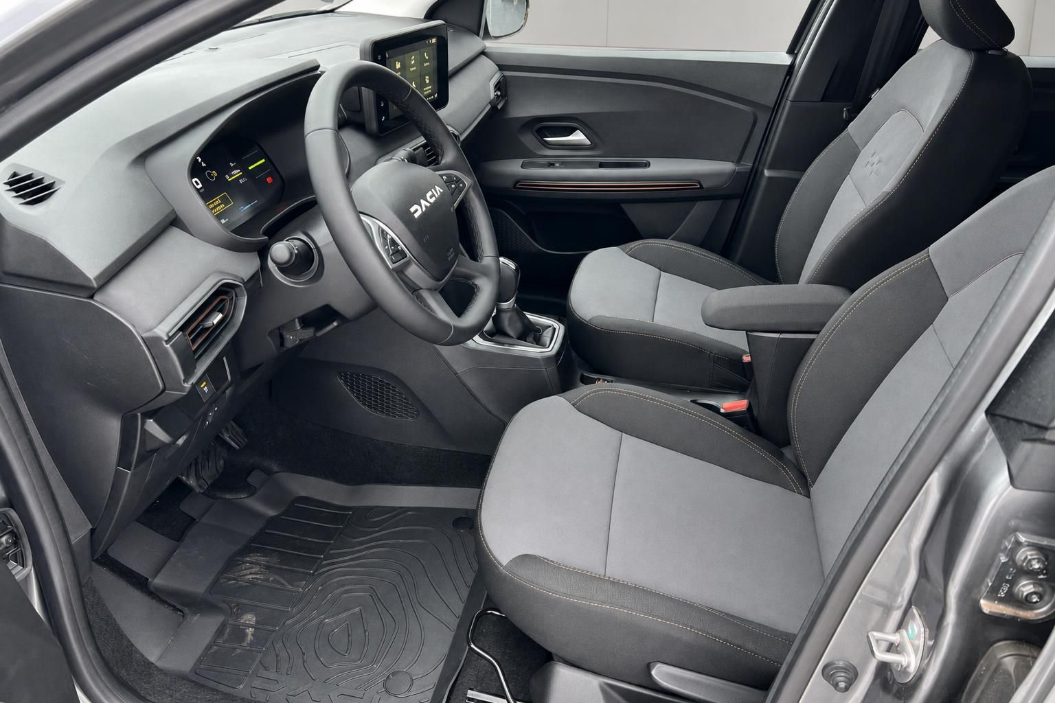 Dacia Innenraum Cockpit mit Touchscreen Display, Lenkrad und grau-schwarzen Sitzen