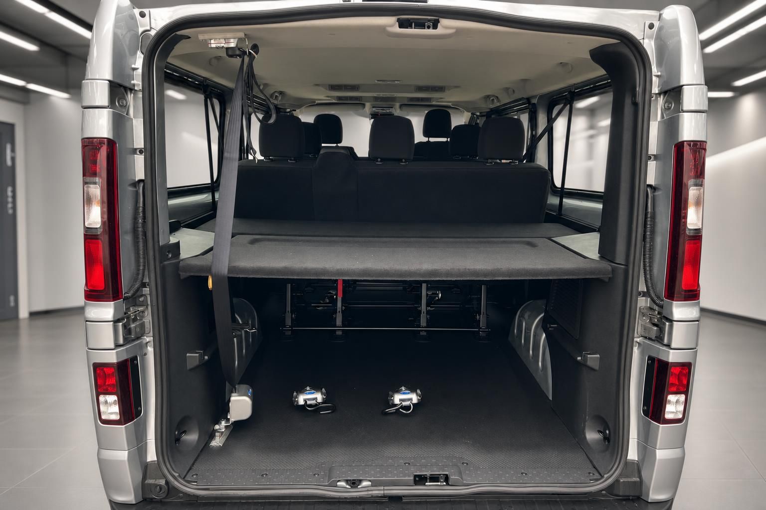 Laderaum und Innenansicht eines silbernen Transporters mit ausklappbarer Liegefläche