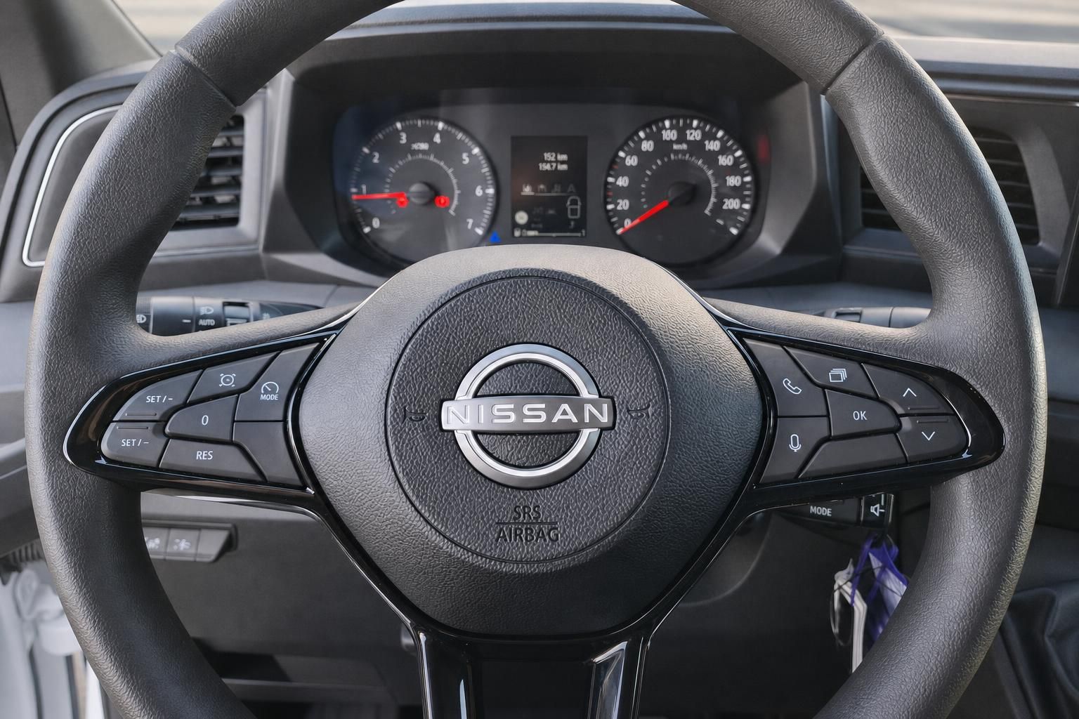 Nissan Lenkrad mit Multifunktionstasten und Instrumentencluster im Hintergrund