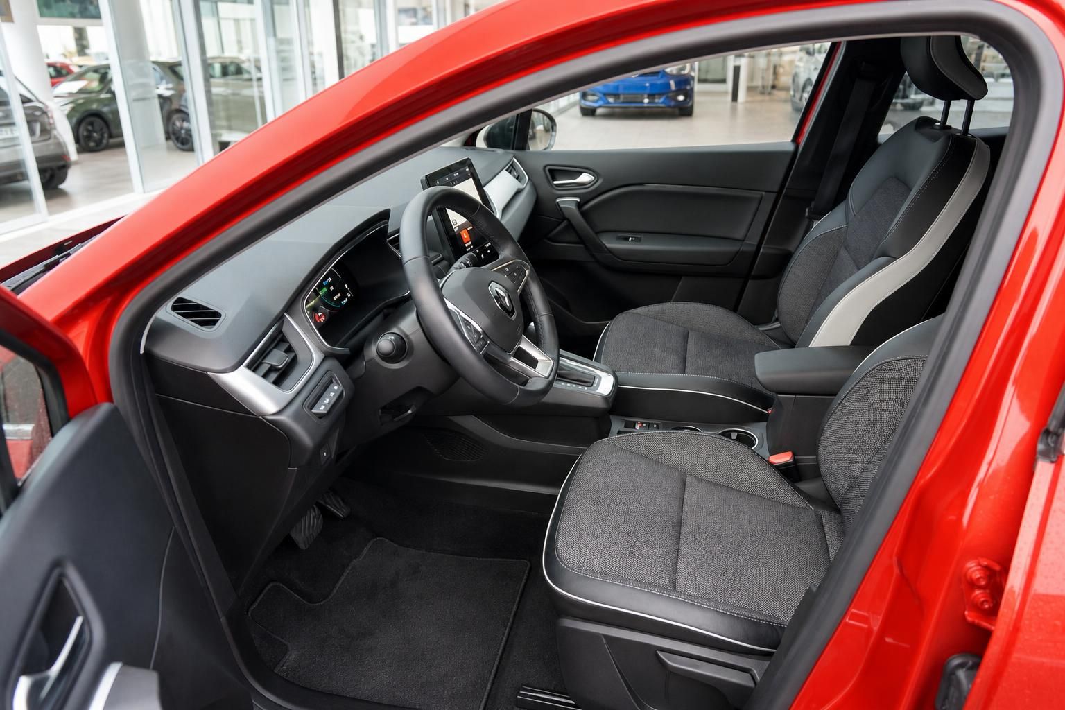 Innenraum mit schwarzen Sitzen und roter Außenlackierung im Autohaus