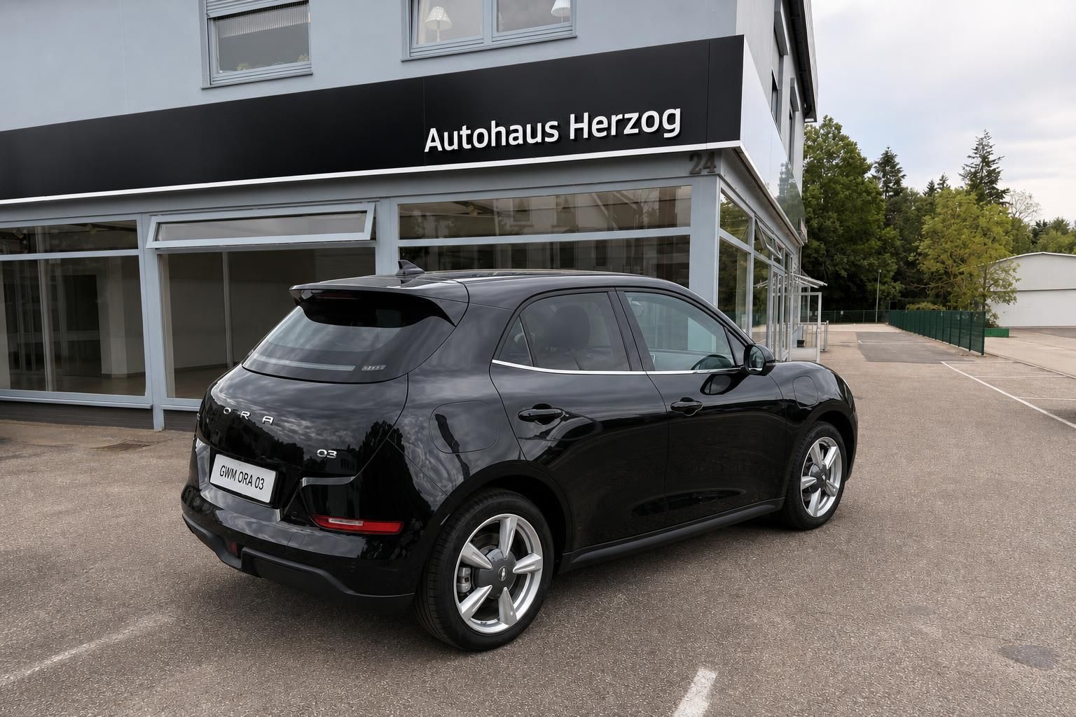 Schwarzer ORA 03 von hinten rechts - Dreiviertel-Ansicht des Elektro-PKW mit elegantem Heckdesign und Spoiler