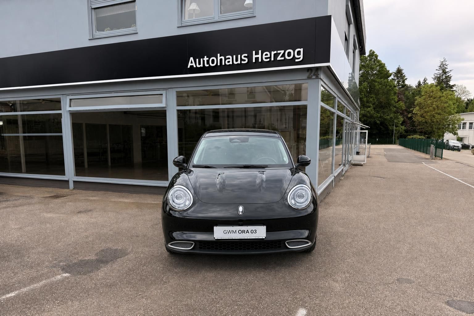 Schwarzer Kompaktwagen Frontansicht vor Autohaus - Elektrofahrzeug mit LED-Scheinwerfern
