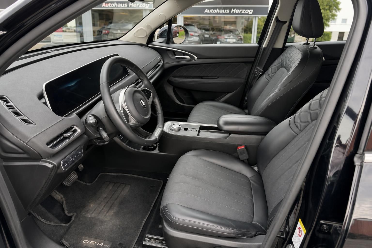 Fahrzeuginnenraum mit schwarzer Ausstattung - Fahrersitz und Cockpit eines modernen Elektroautos