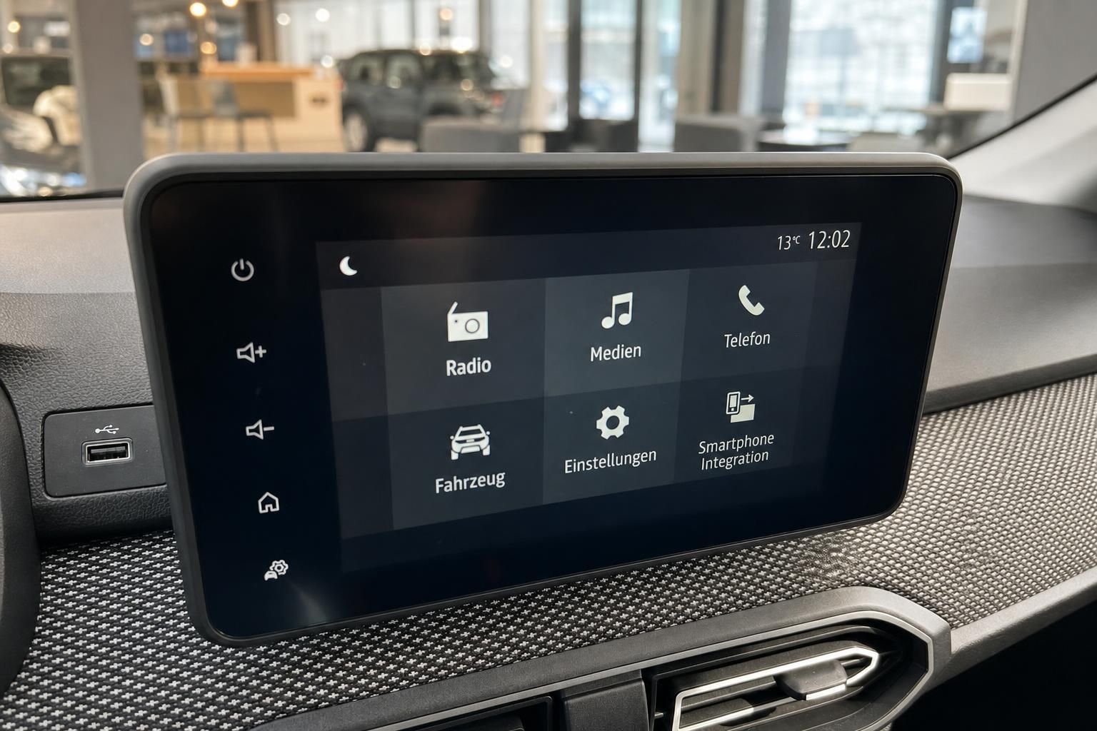 Touchscreen-Infotainmentsystem mit Hauptmenü und USB-Anschluss im Fahrzeug