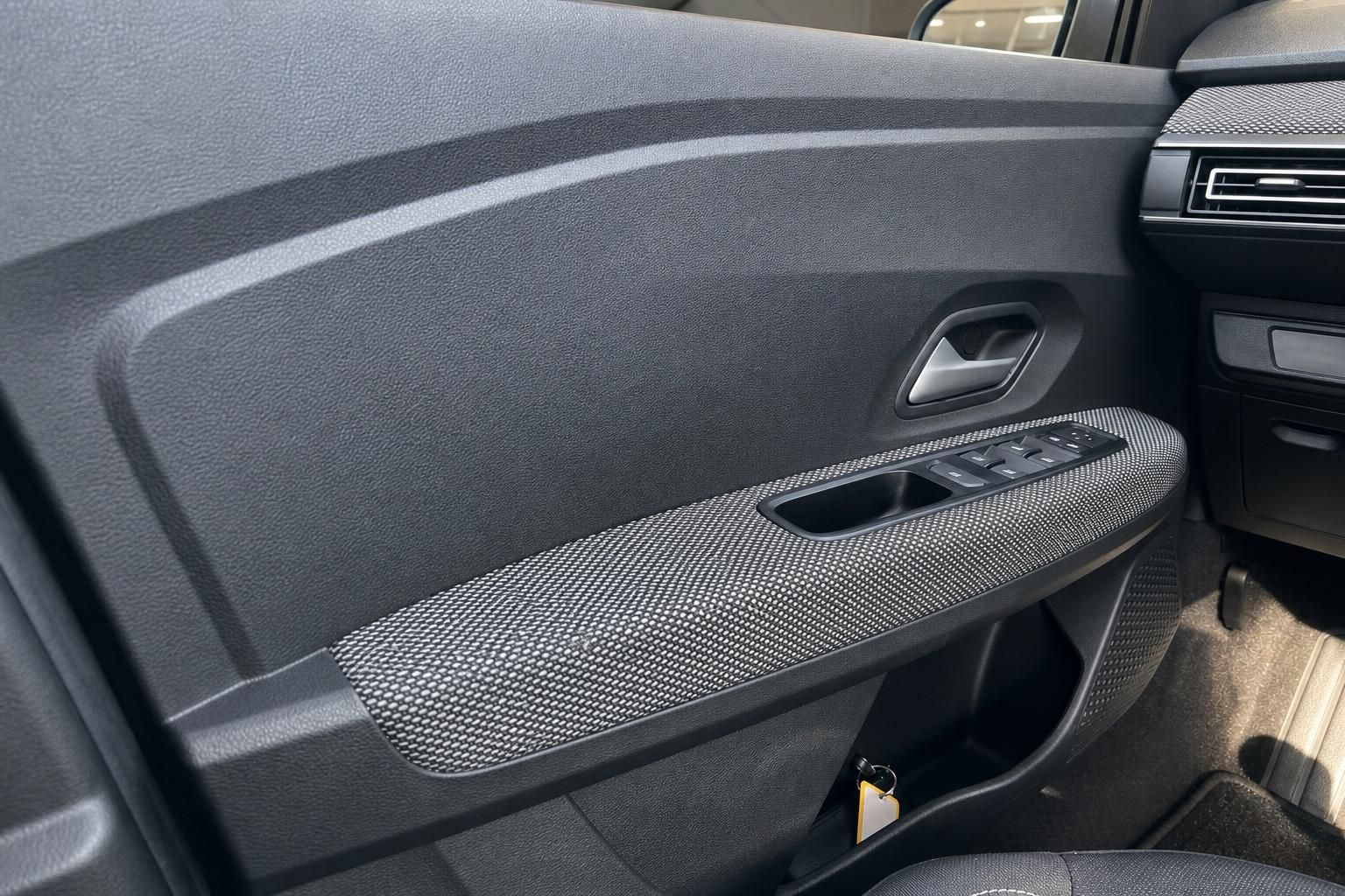 Türverkleidung mit Fensterheber-Bedienung und Stoffbezug im Fahrzeuginnenraum