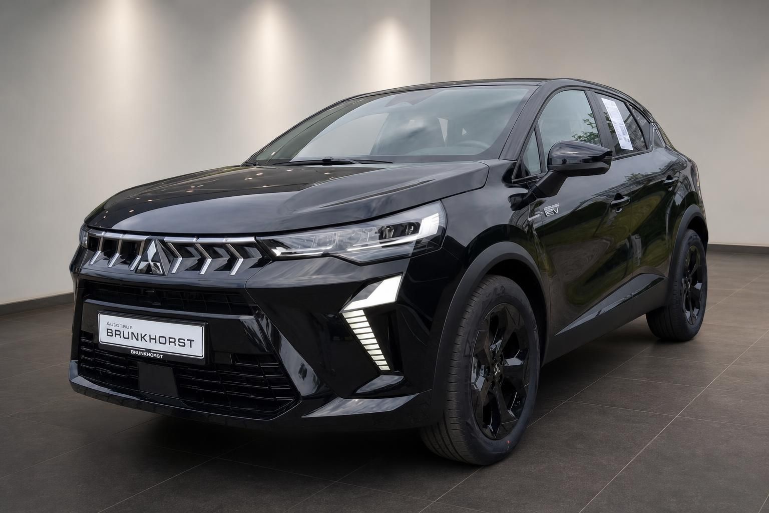 Schwarzer Mitsubishi ASX HEV Hybrid-SUV Frontansicht mit LED-Scheinwerfern im Autohaus Brunkhorst