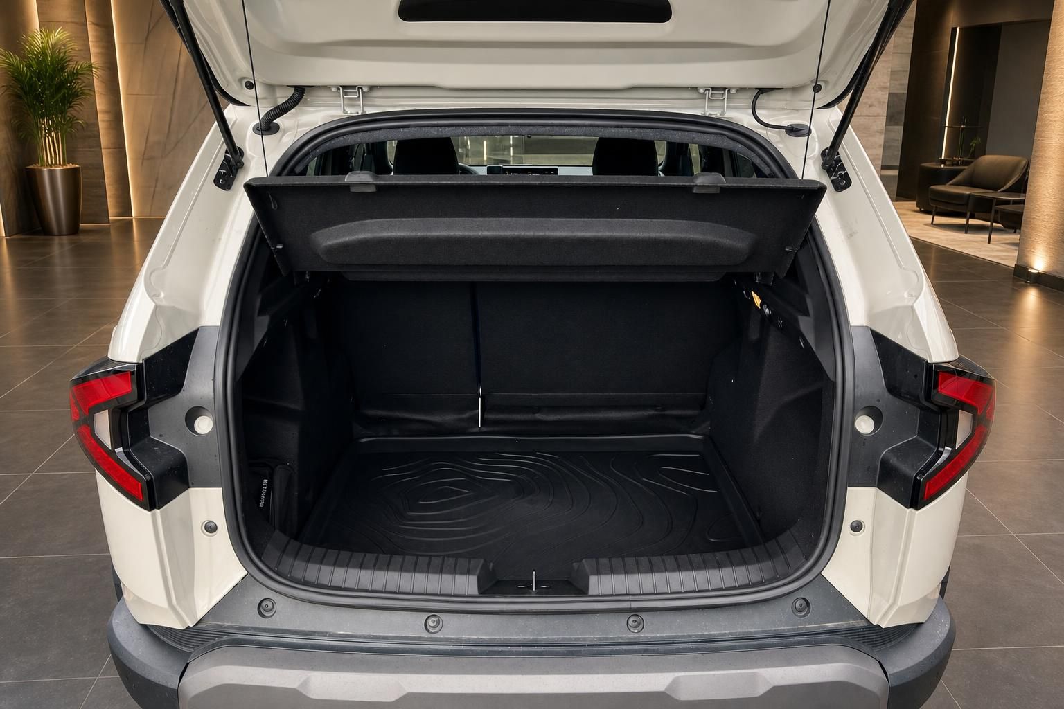 Offener Kofferraum eines weißen SUV mit schwarzer Kofferraummatte in modernem Autohaus Showroom